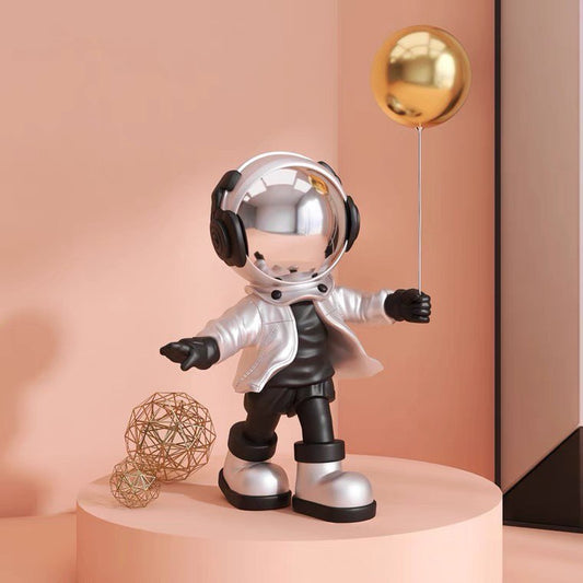 Silver astronaut figurine with ball