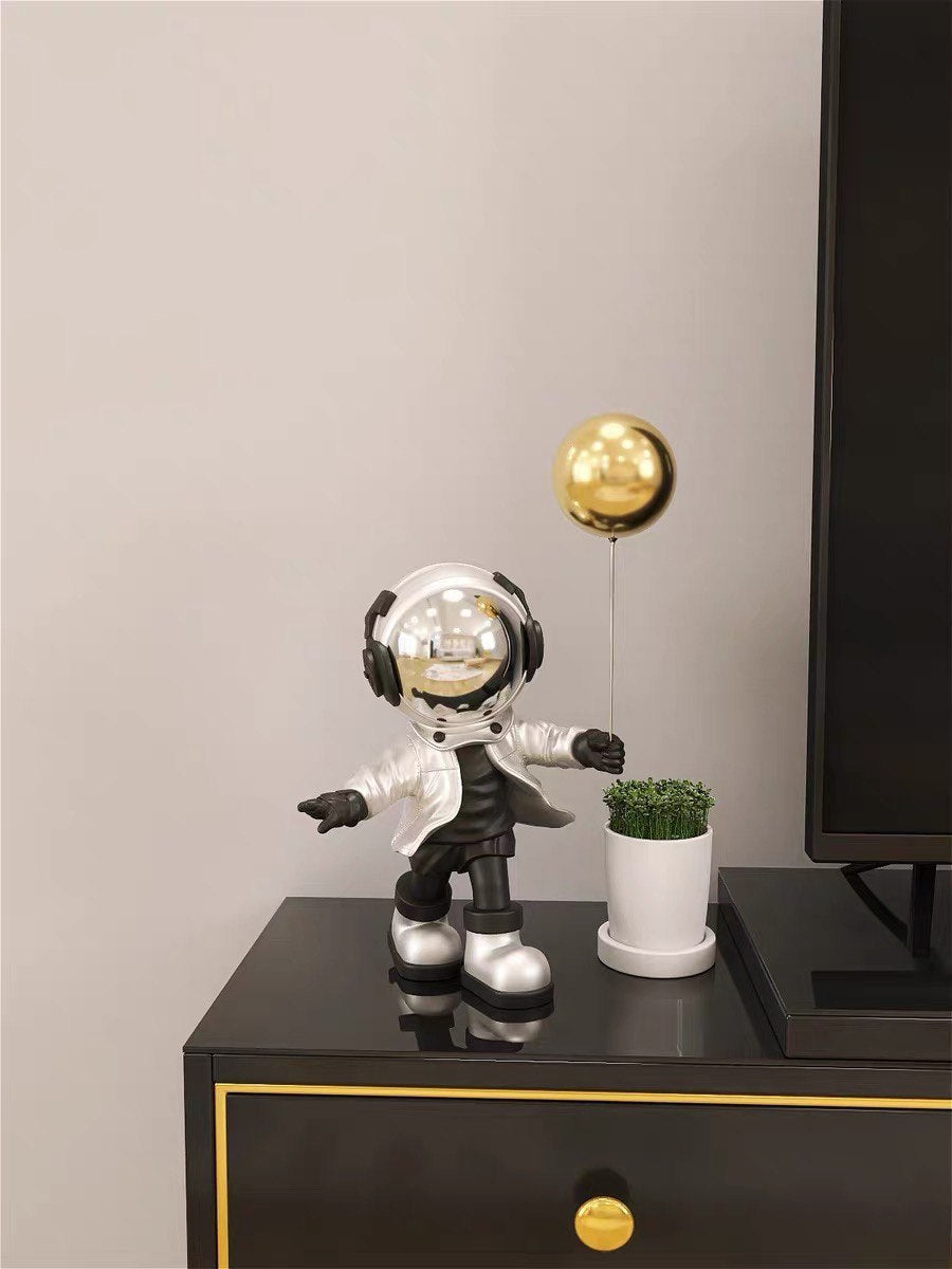 Silver astronaut figurine with ball