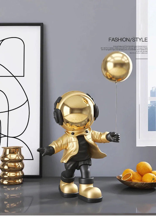 Gold astronaut figurine with ball