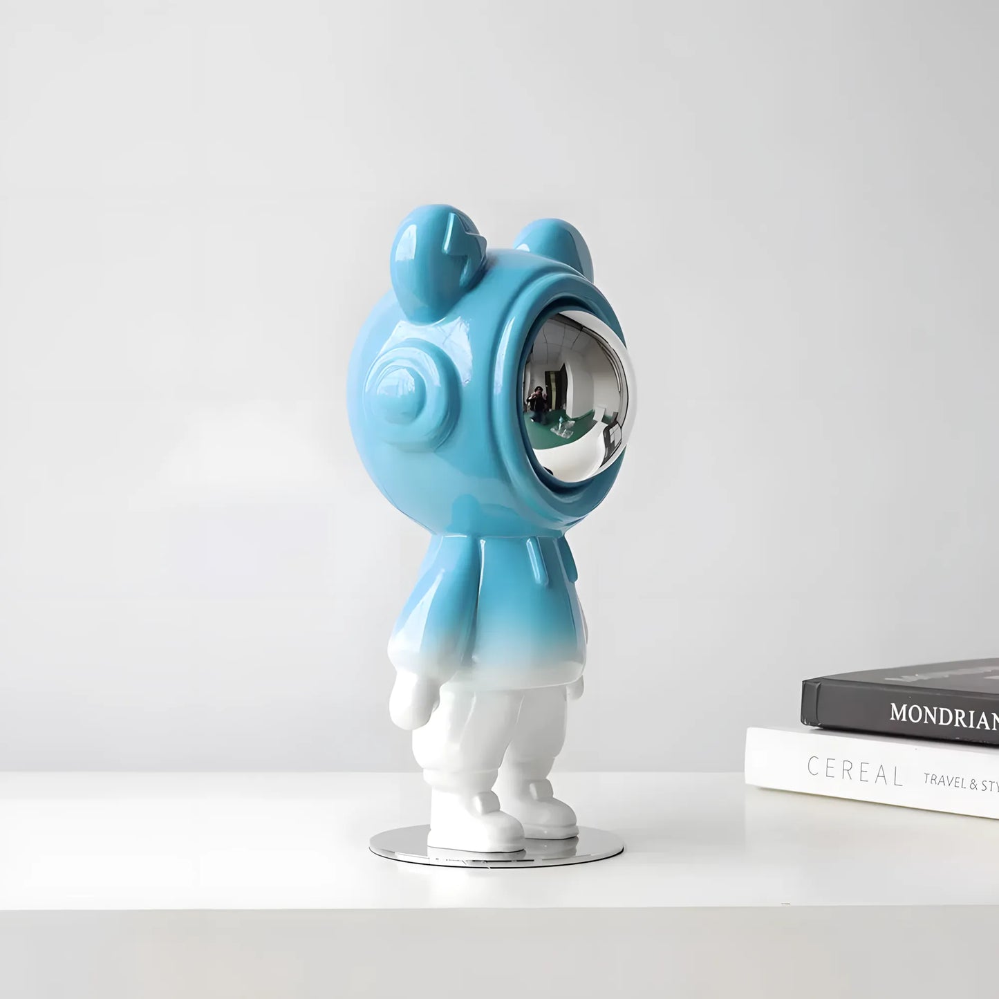 Side profile view of the futuristic sky blue and white gradient space explorer bear figurine on a white table