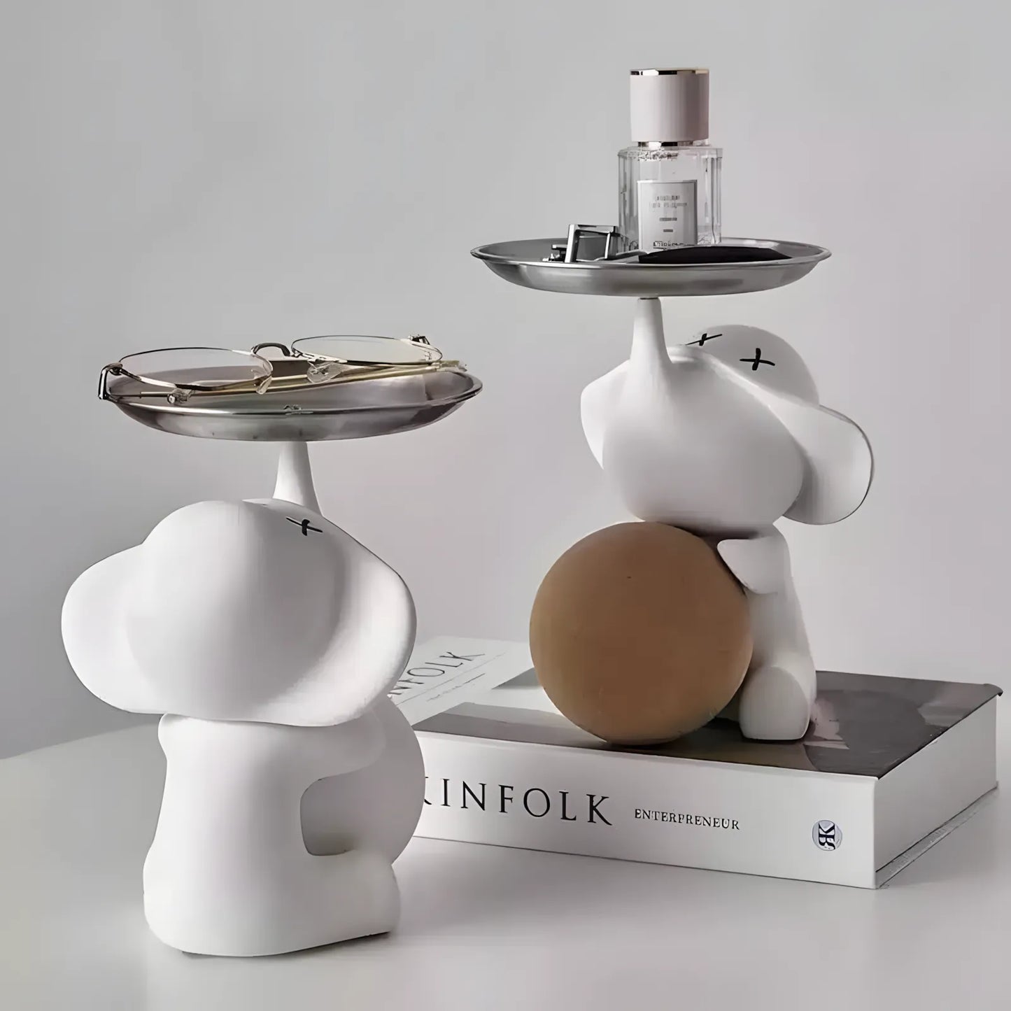 Stylish matte white elephant valet tray organizer holding a wrist watch on a bedside table nightstand