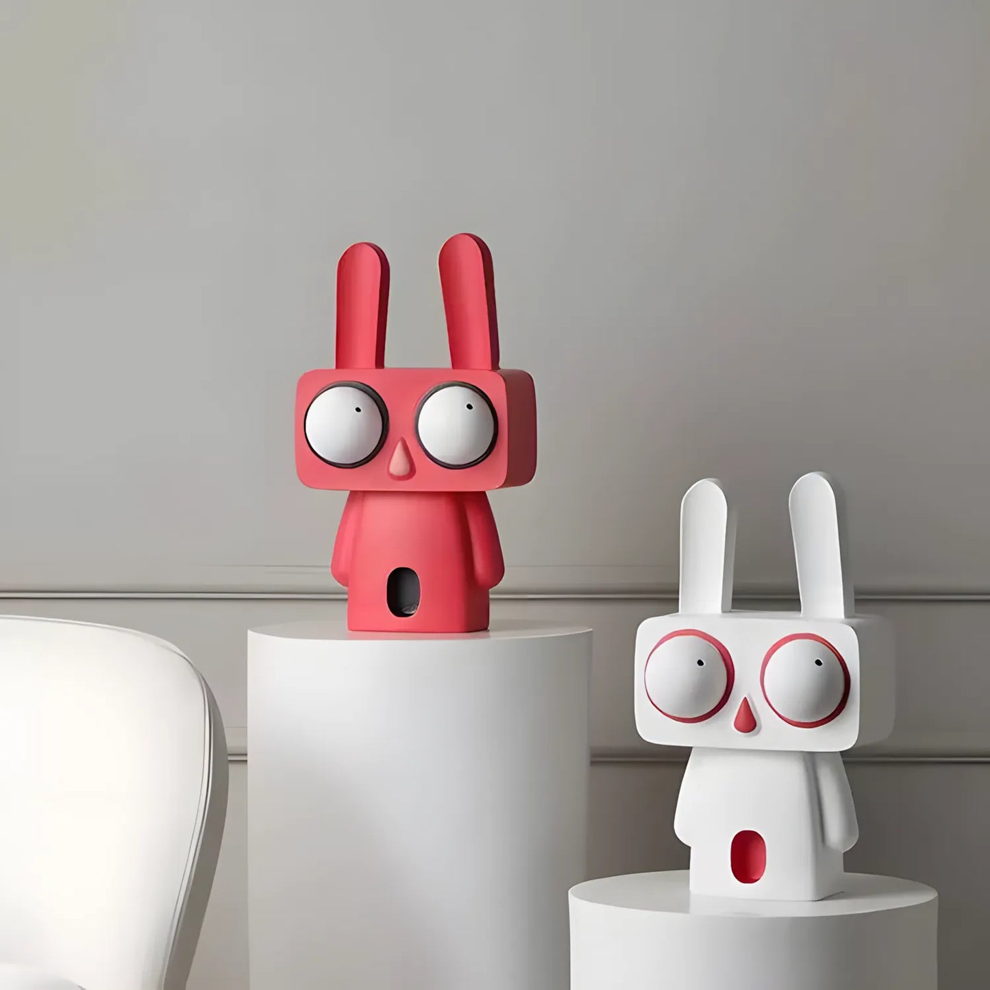 The coral red pop art rabbit figurine with big eyes sitting on a light wooden table in a colorful children playroom background
