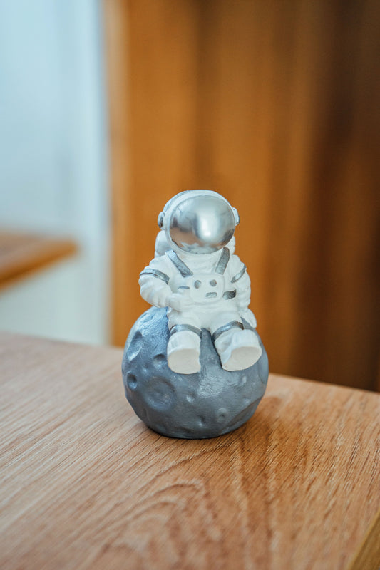 Astronaut figurine. Figurine for the interior astronaut sitting on the moon silver