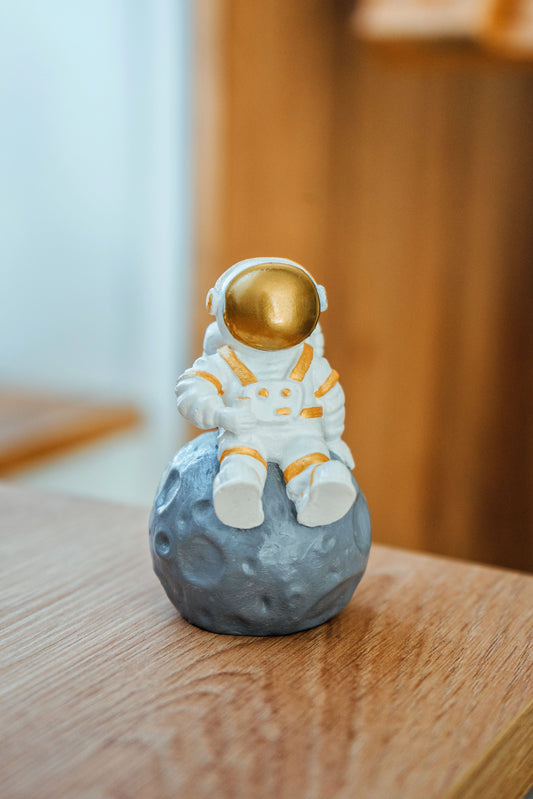 Astronaut figurine. Figurine for the interior astronaut sitting on the moon gold