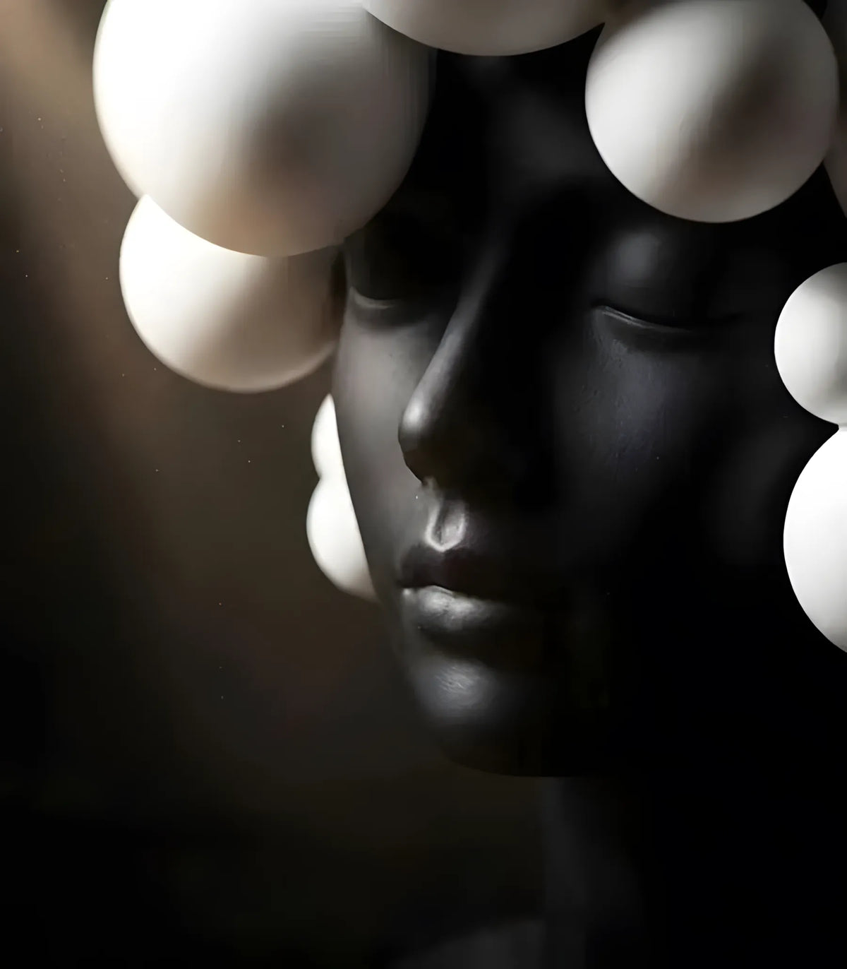 Black sculpture of a face with white spherical elements on a dark background