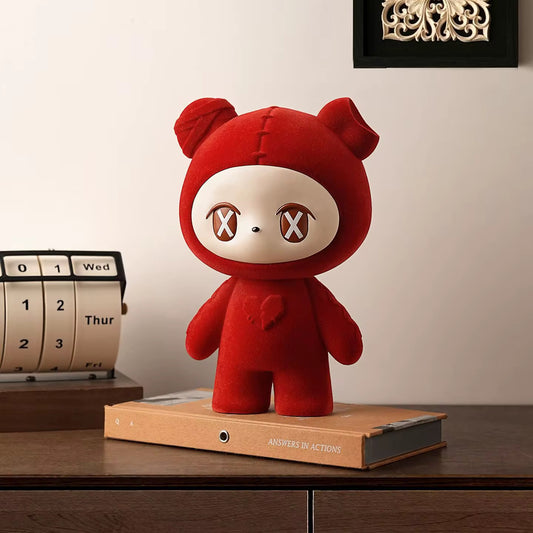 Red plush toy with a neutral expression on a wooden surface next to a calendar.