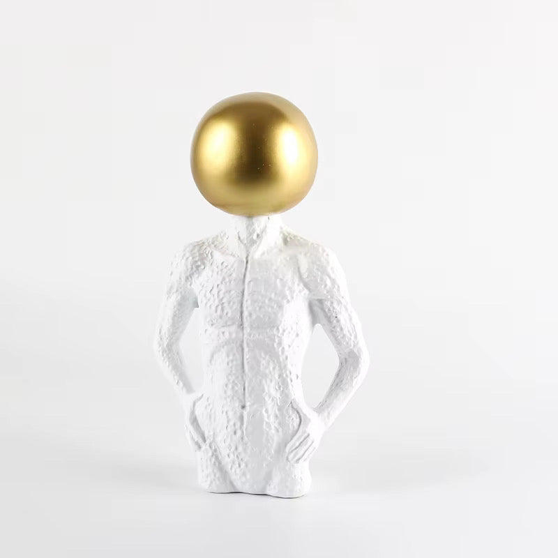 White sculpture with a gold sphere on a white background