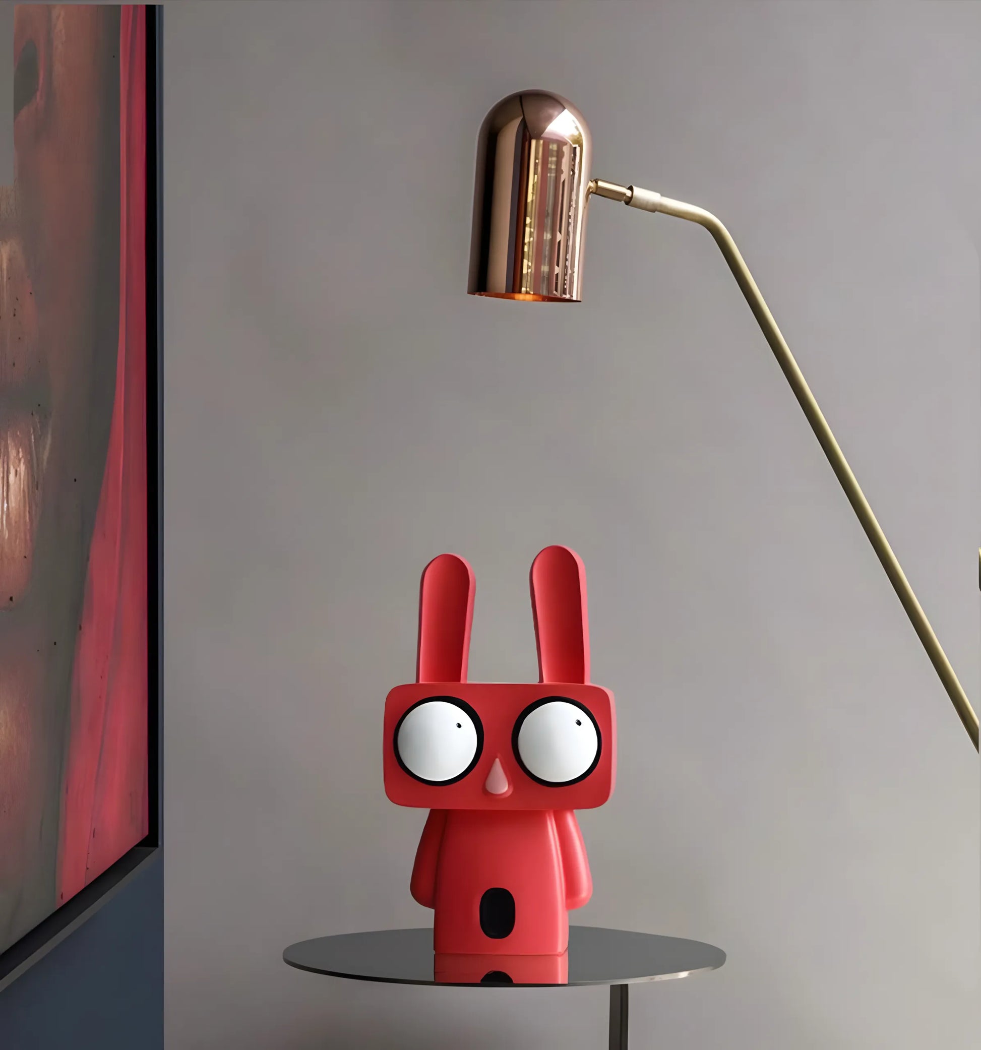Two pop art rabbit figurines in coral red and minimalist white standing on separate white cylindrical display pedestals