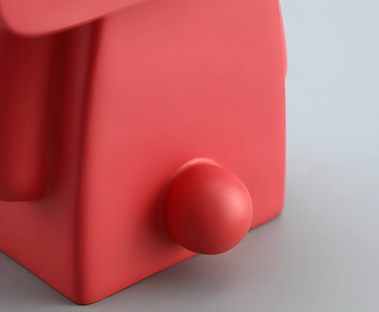 Two pop art rabbit figurines in coral red and minimalist white standing on separate white cylindrical display pedestals