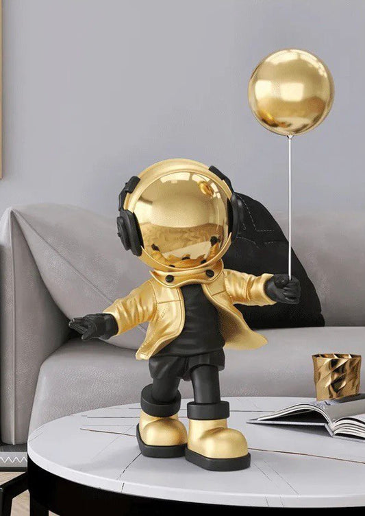 Gold astronaut figurine with ball